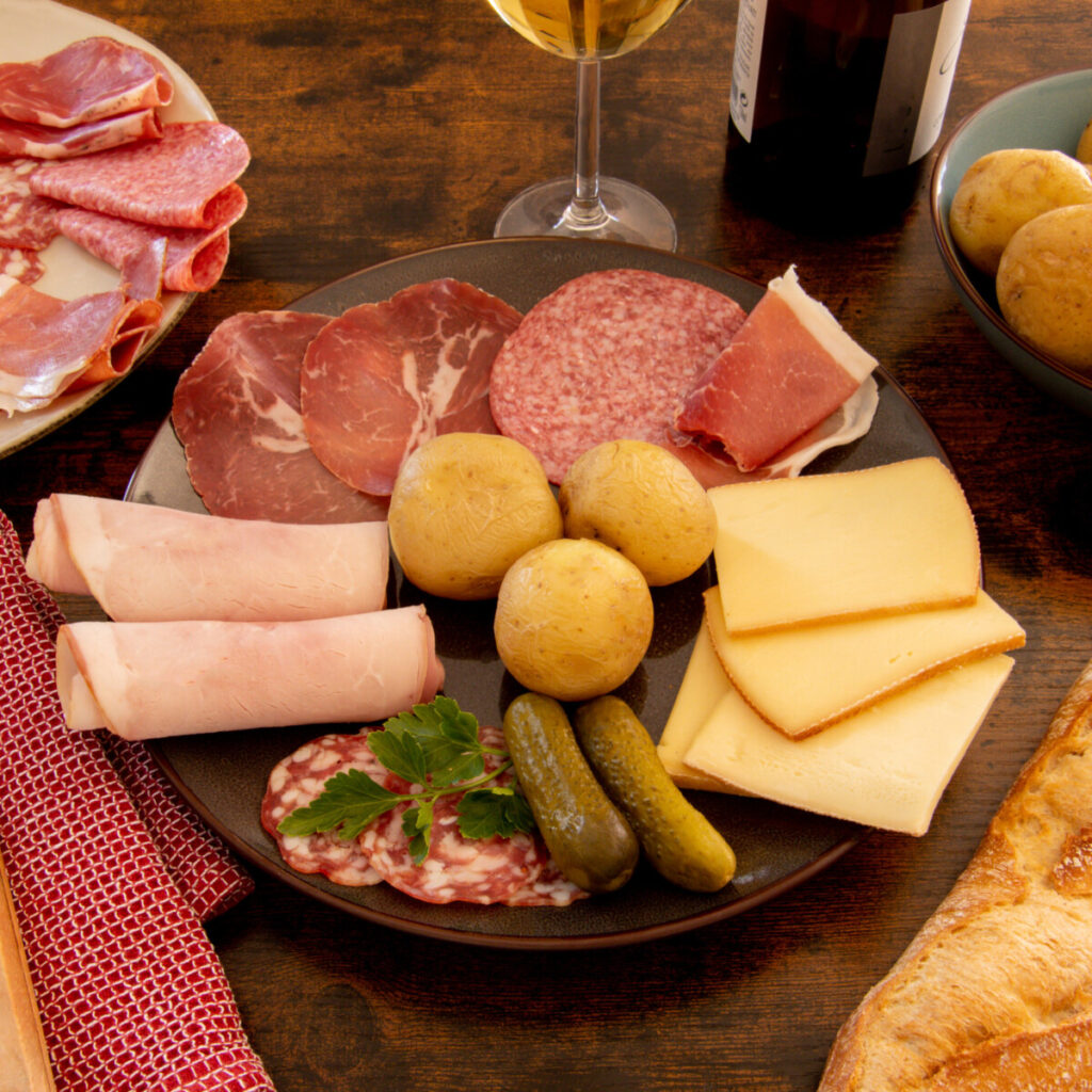 Plateau de charcuterie servi avec une raclette